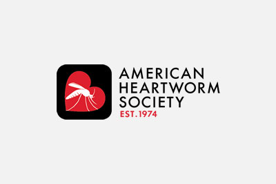 Logo of the American Heartworm Society, designed for veterinarians, featuring a red heart with a white silhouette of a heartworm inside, next to the text "American Heartworm Society est. 1974" on a gray background.