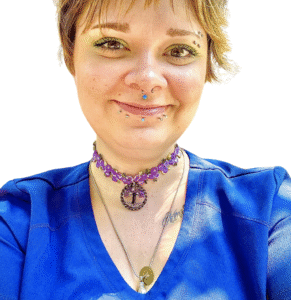 A veterinarian wearing a blue scrub top and smiling gently against a plain white background.