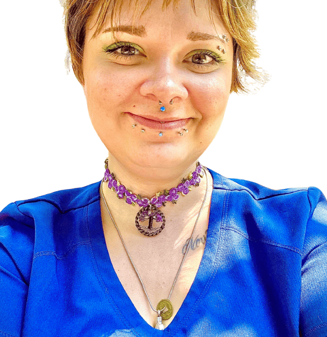 A veterinarian wearing a blue scrub top and smiling gently against a plain white background.